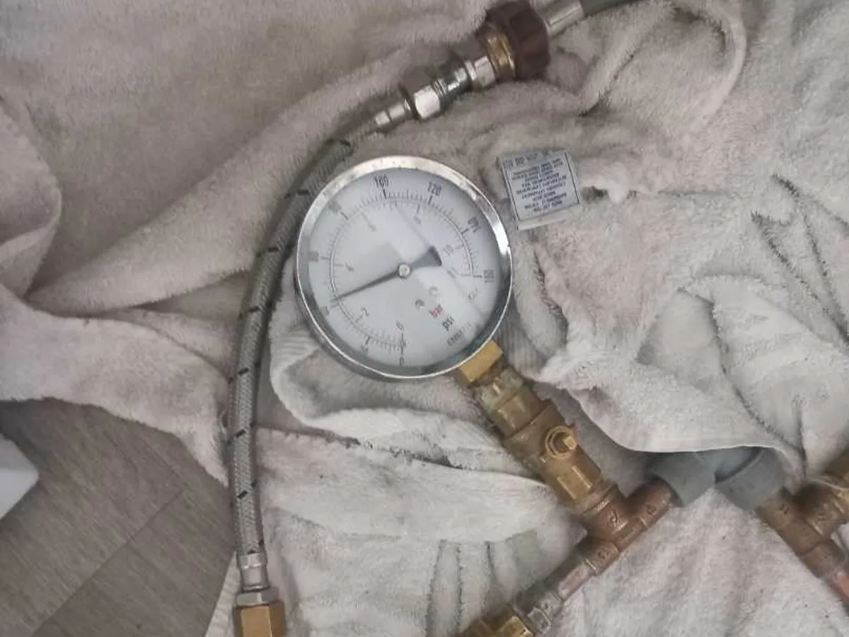 pressure test gauge and brass manifold in use during leak detection investigation