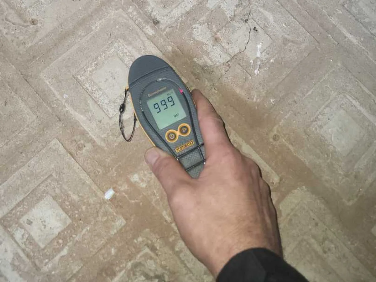 moisture meter reading 99.9 on laundry room floor during leak detection
