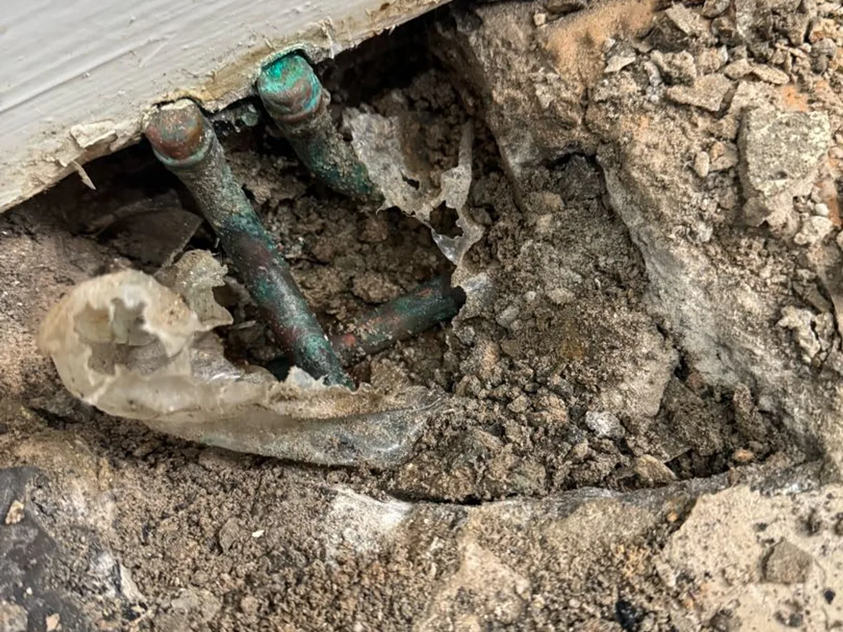leak located at corroded copper pipework exposed beneath kitchen floor with saturated ground