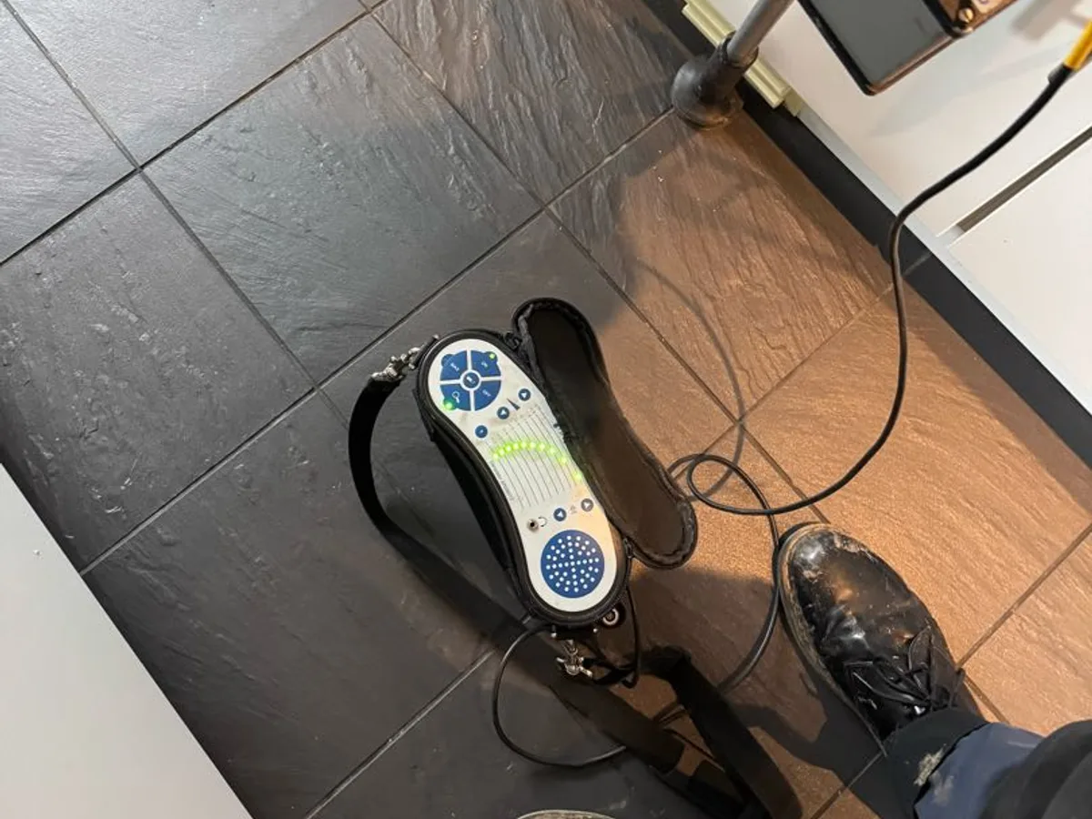 ground microphone and tracer gas detector in use on kitchen tiled floor during investigation — during leak detection