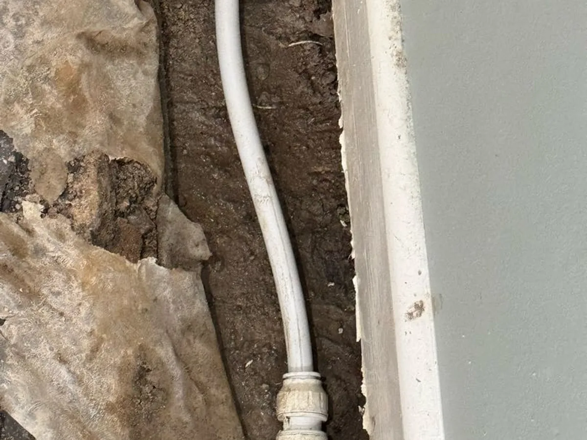 new MDPE transitional coupling and speedfit pipe installed as repair completed in kitchen floor trench