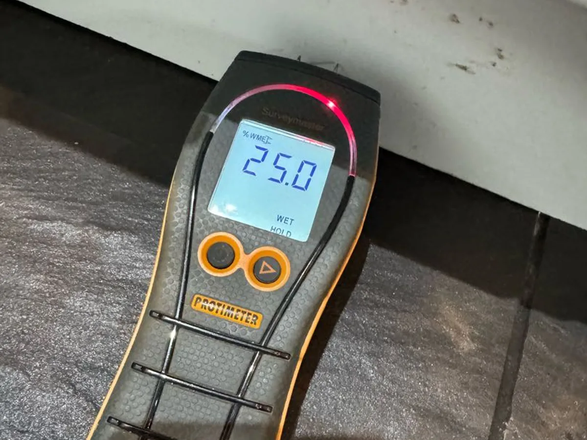 moisture meter reading 25 on kitchen tiled floor during leak detection survey