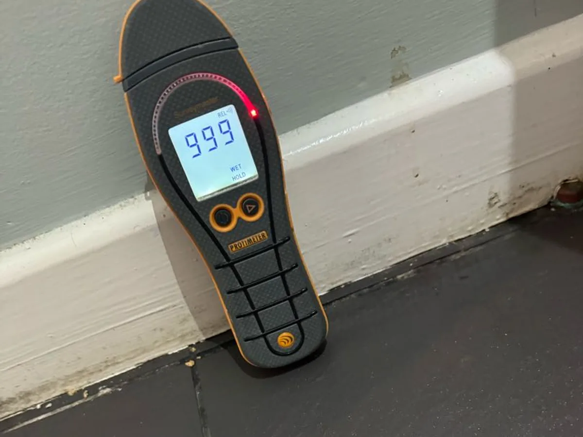 moisture meter reading 999 at skirting board on tiled kitchen floor during leak detection