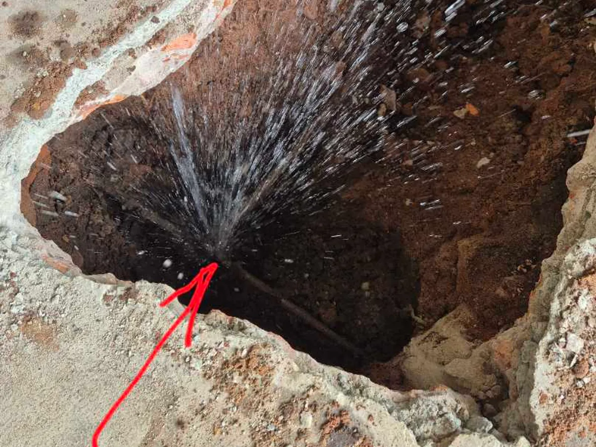 leak found at snapped copper pipe branch spraying water under garage floor