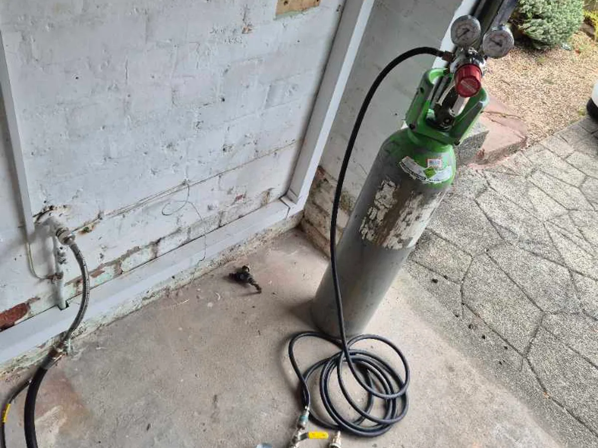 tracer gas cylinder and manifold connected to garage tap fitting during leak detection
