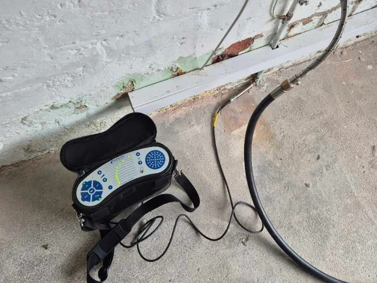 tracer gas detector unit connected to garage pipework tap during leak detection survey