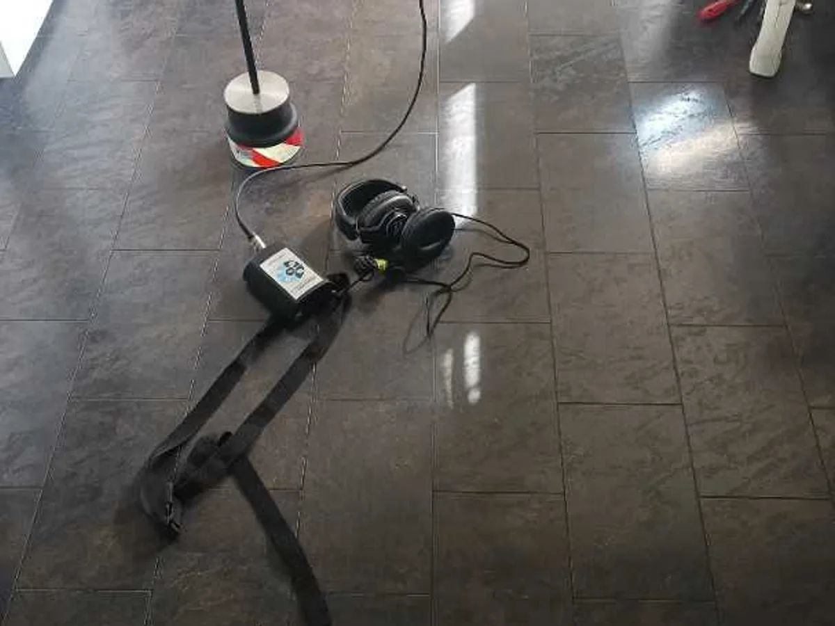 acoustic listening device with ground microphone and headset on kitchen floor during leak detection