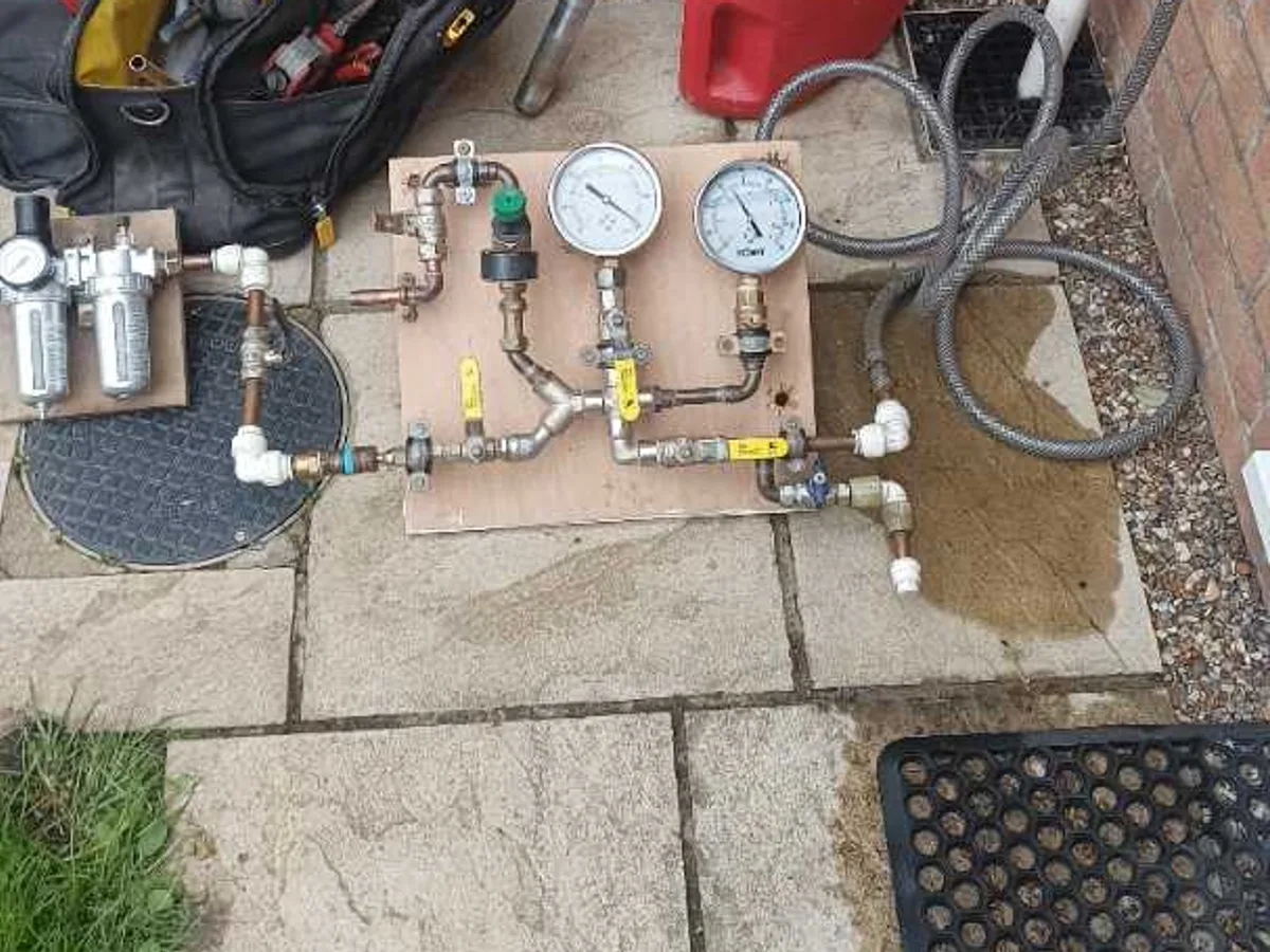 dual-gauge pressure test rig set up on patio during leak detection