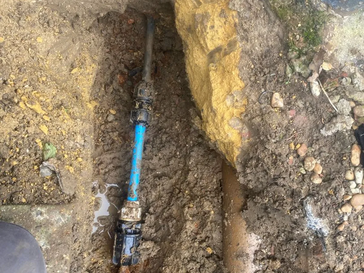 blue MDPE pipe with transition couplings replacing corroded steel mains pipe, repair in progress