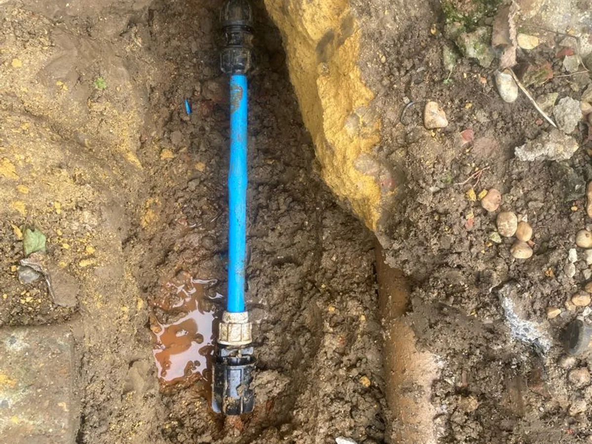 extended blue MDPE section with transition couplings after repair completed on corroded steel mains