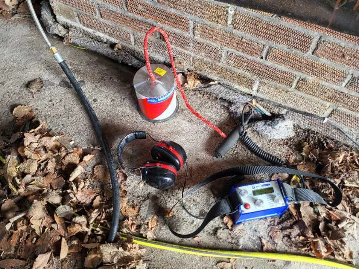 acoustic correlator and tracer gas cylinder on garage floor during leak detection survey