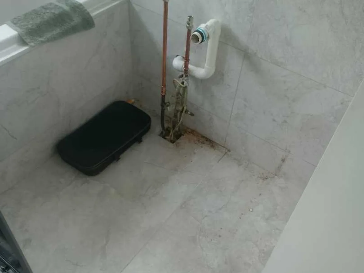 exposed pipework and stop tap in cloakroom after basin removal during leak detection