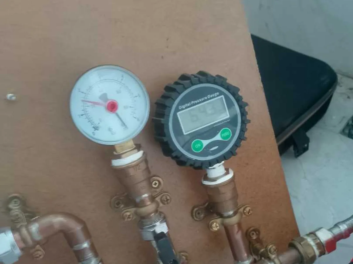 dual pressure gauges connected to copper manifold during leak detection survey