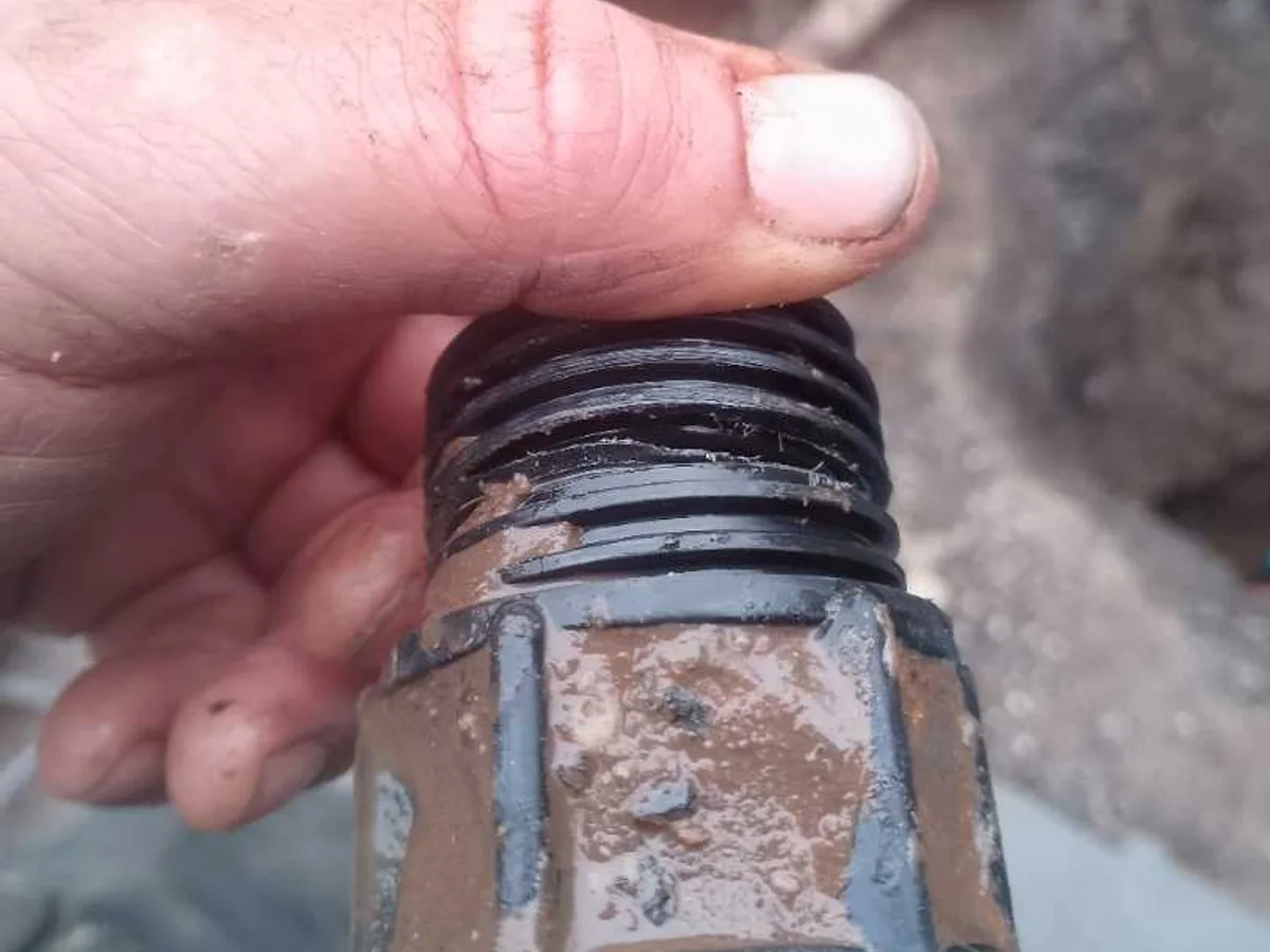 fault identified at cross-threaded snapped underground mains coupler removed from ground — leak located at