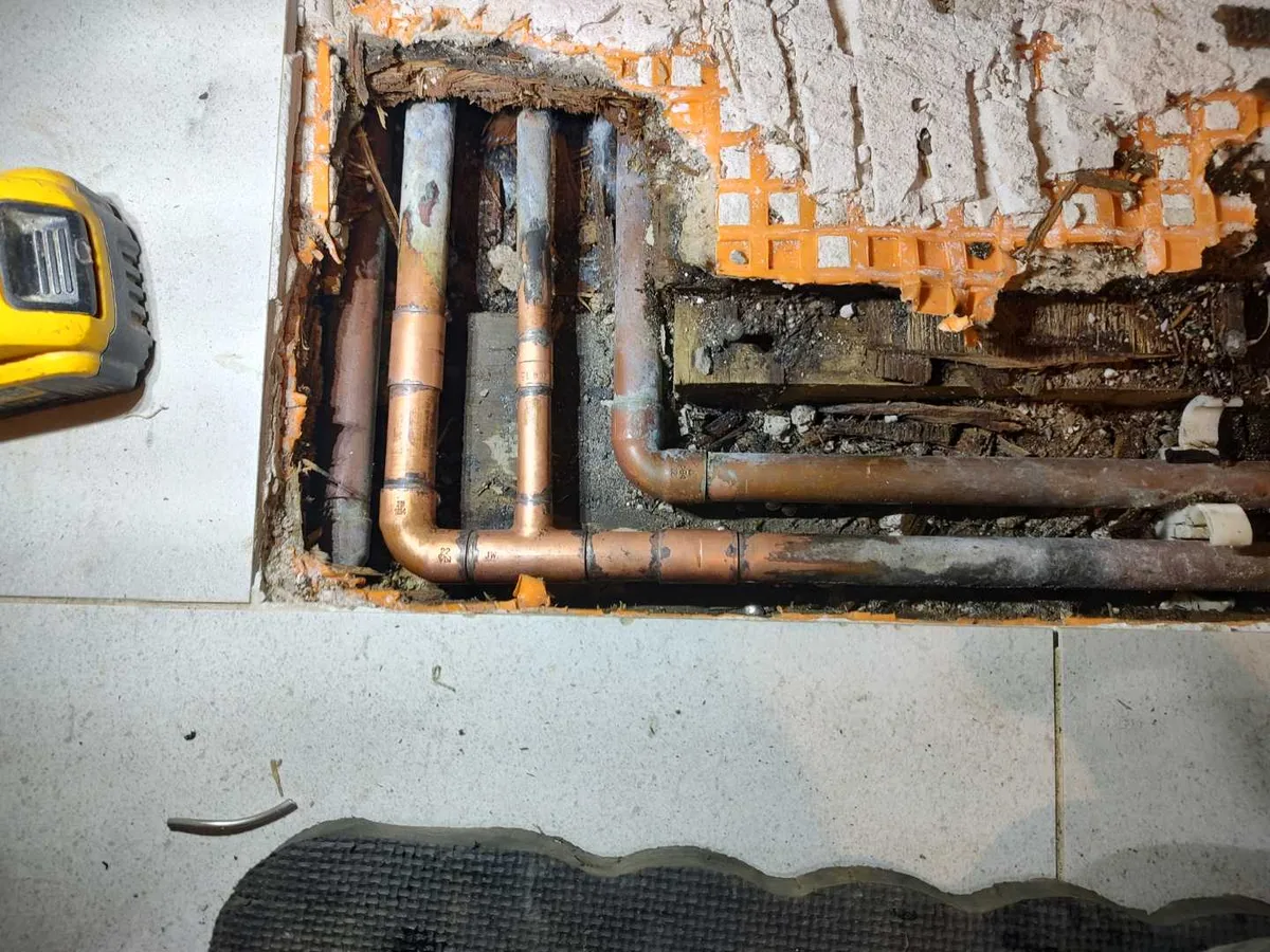new copper pipe and fittings installed in corridor floor void as repair completed