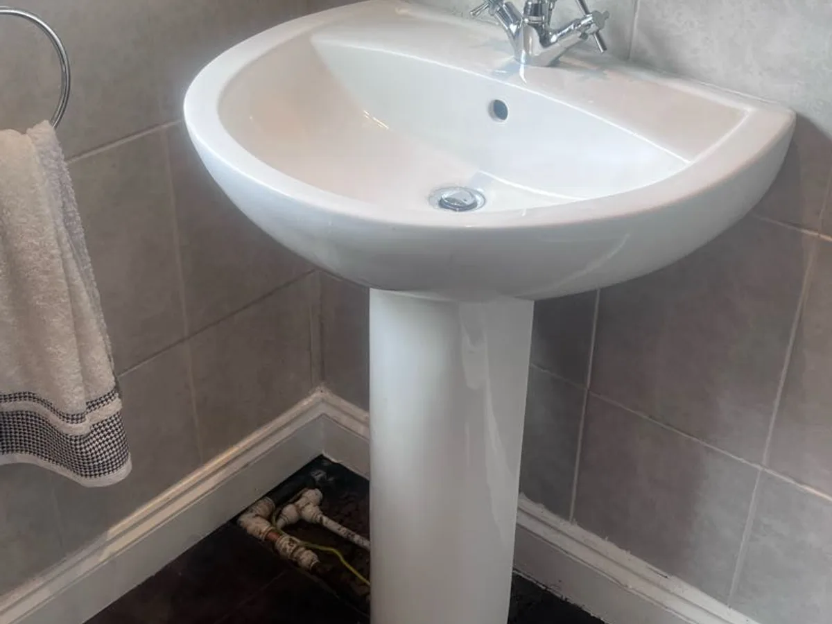 pedestal basin refitted in bathroom after works completed following pipe repair