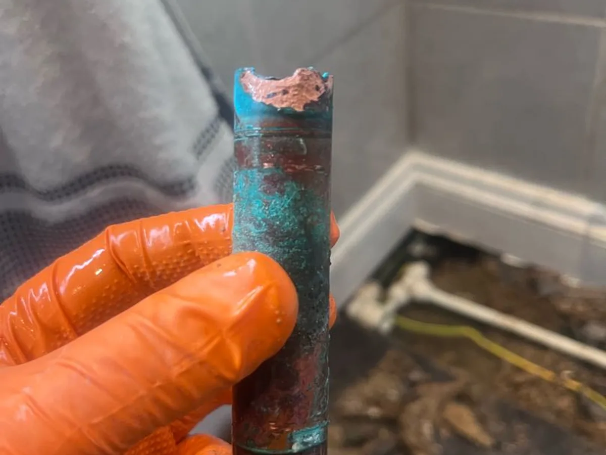 fault identified at heavily corroded section of copper pipe removed from beneath bathroom floor — leak located at