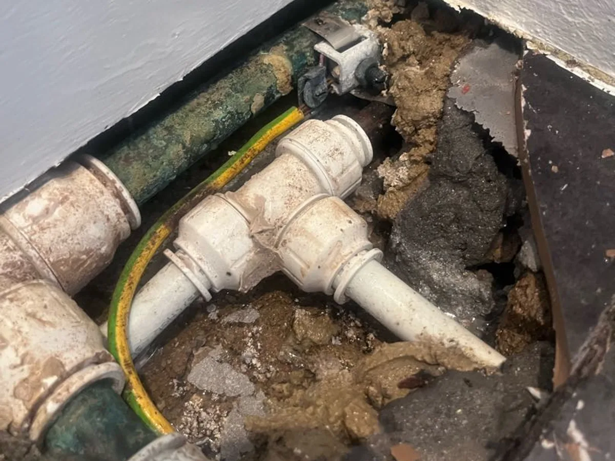 leak located at unprotected push-fit couplings embedded in screed beneath bathroom floor tiles