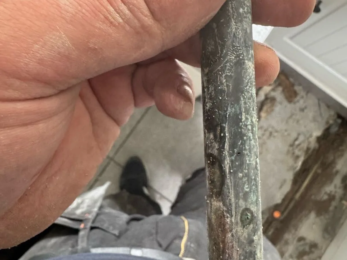 leak found on heavily corroded section of copper pipe removed from below floor — leak located at