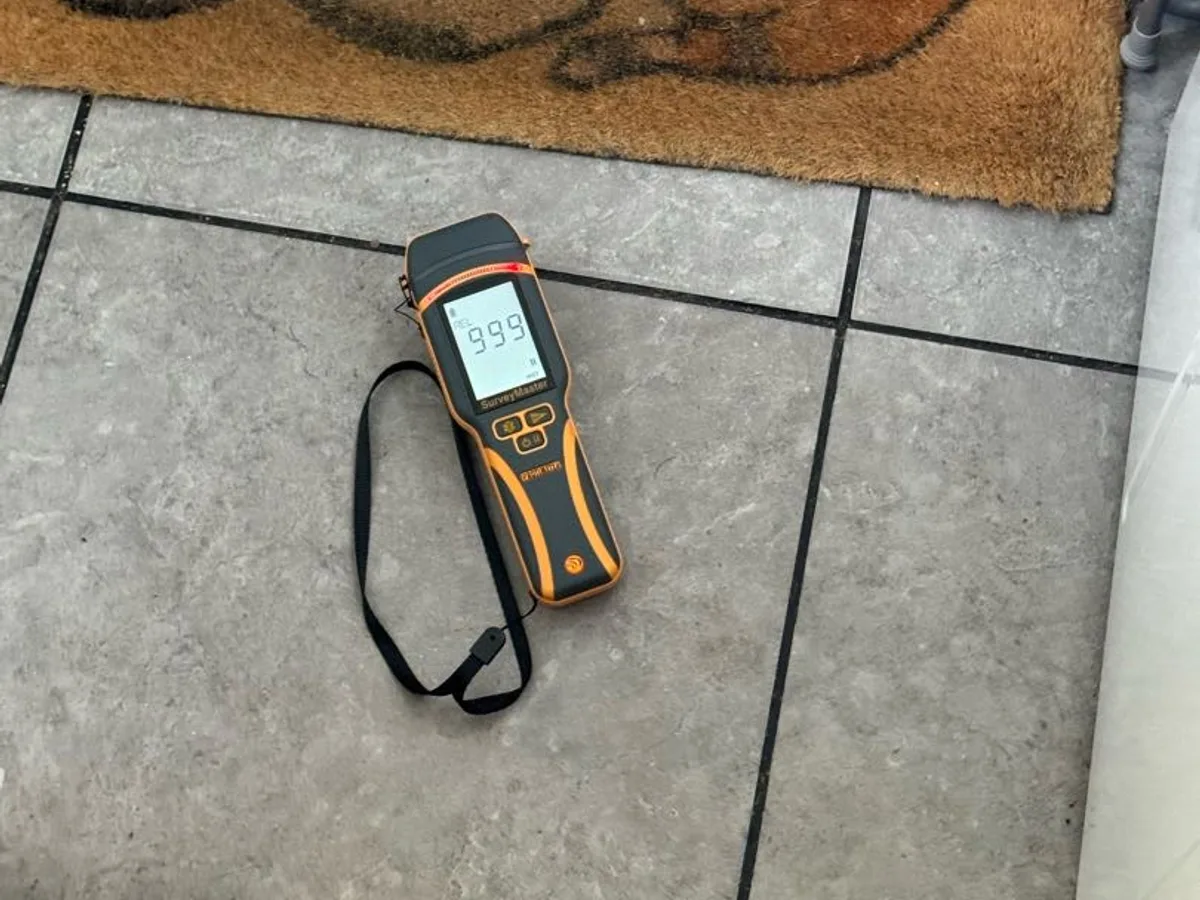 damp meter reading 99 on utility room floor tiles during leak detection survey
