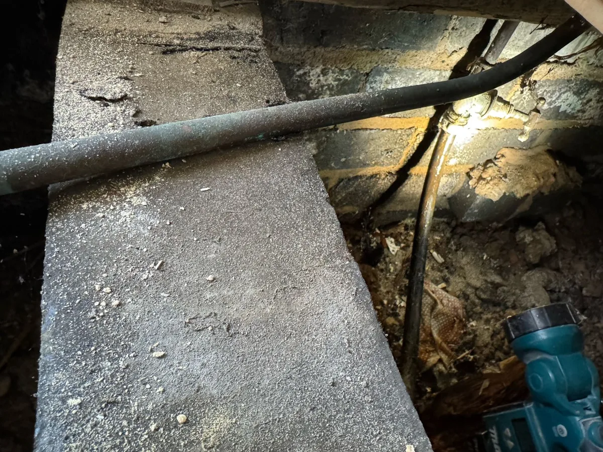 leak located at buried pipework exposed beneath lifted kitchen floorboards