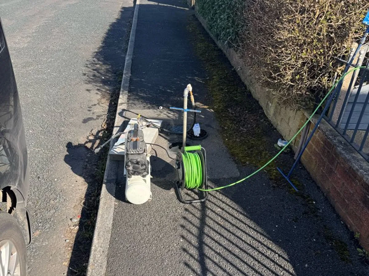 air compressor and hose reel set up on driveway during leak detection