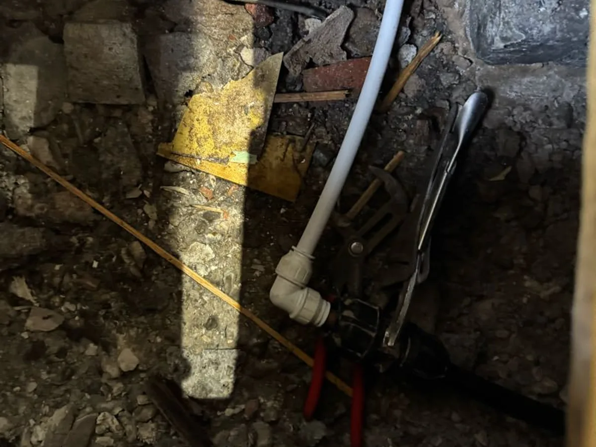 new barrier pipe section with transitional coupling fitted during repair in progress beneath kitchen floor