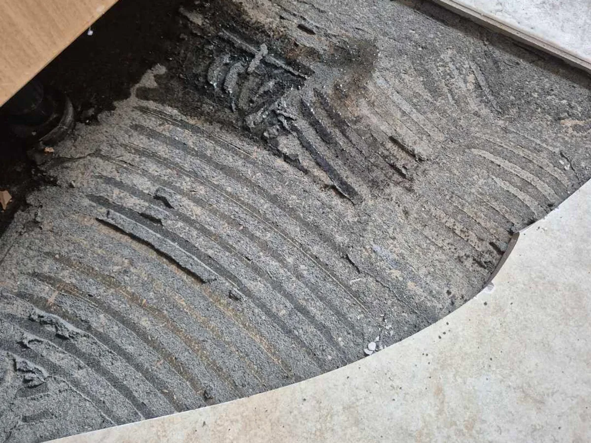 wet concrete subfloor exposed after tile removal during leak detection investigation