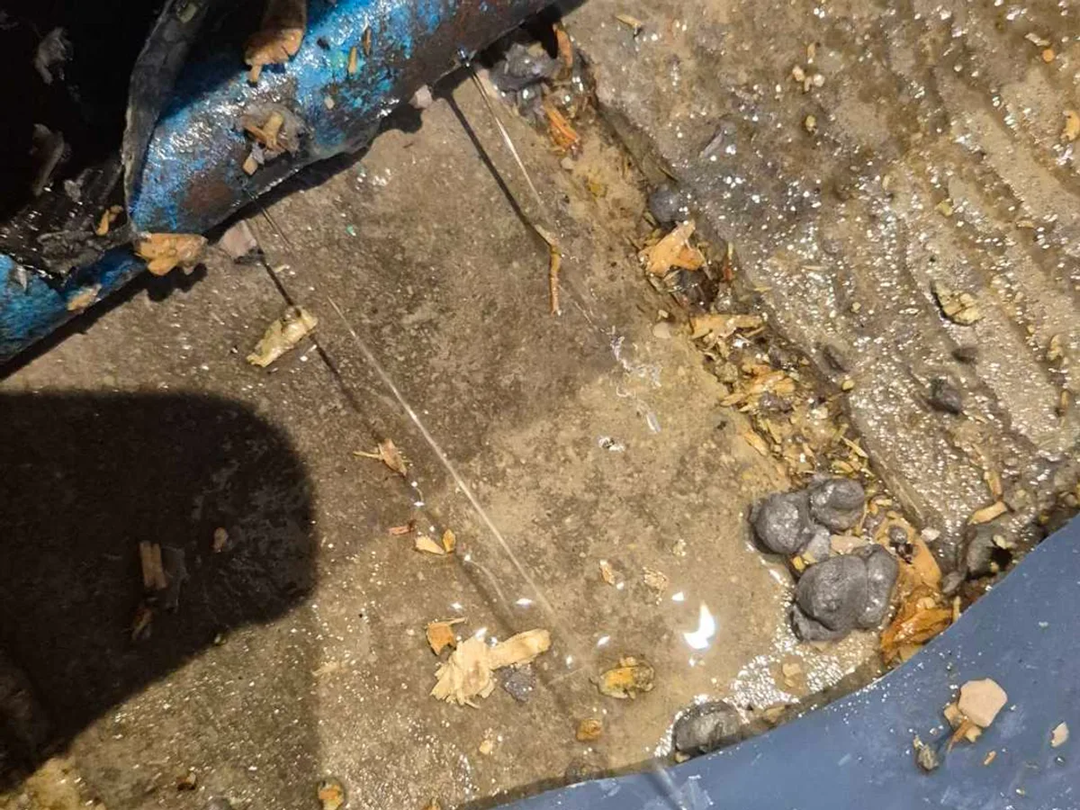 leak found at split 15mm copper mains pipe with water pooling on concrete floor beneath kitchen