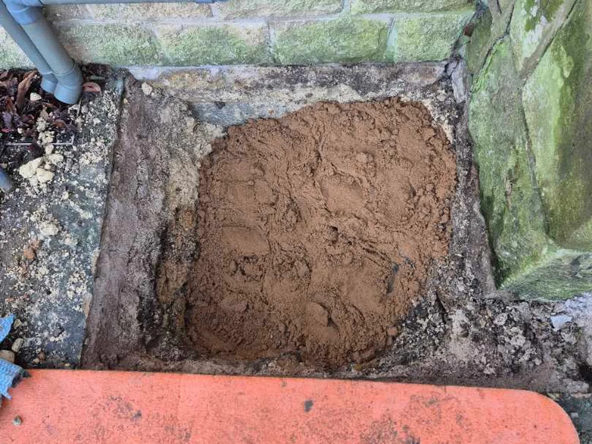 excavation pit backfilled with building sand following reinstatement after temporary repair