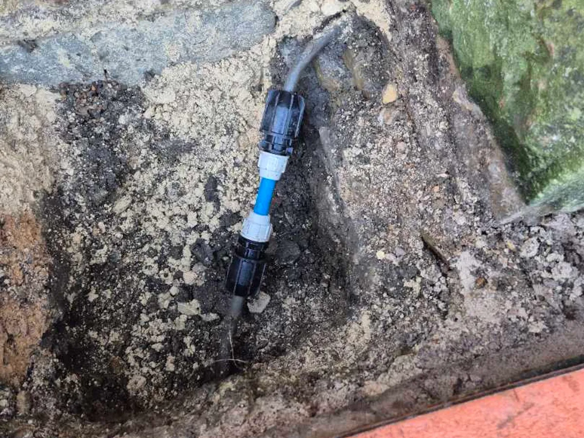 blue MDPE pipe section with transition couplers installed as repair completed on lead water main