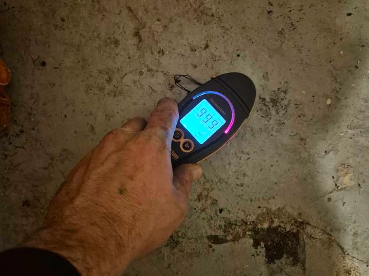 moisture meter reading 99.9 on wet basement floor during leak detection