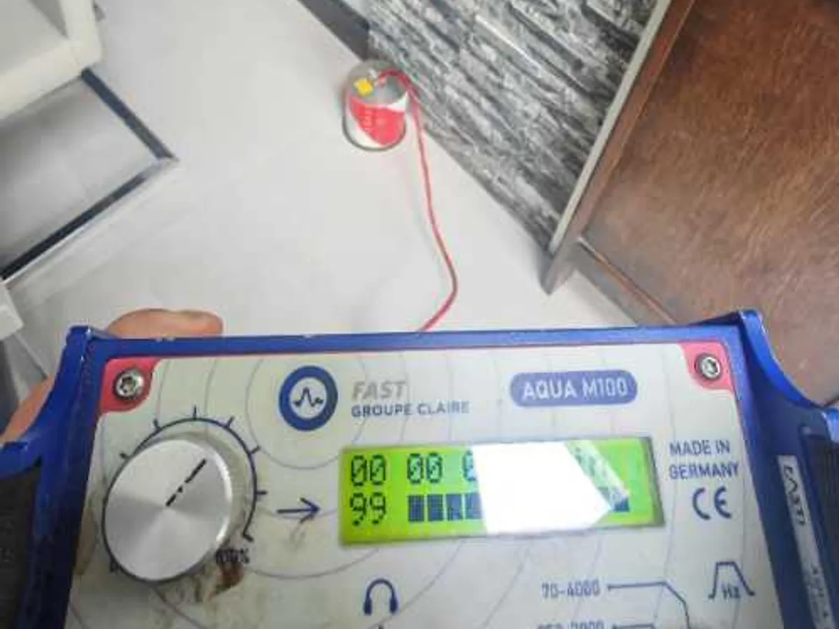 acoustic correlator unit displaying readings on tiled floor during leak detection