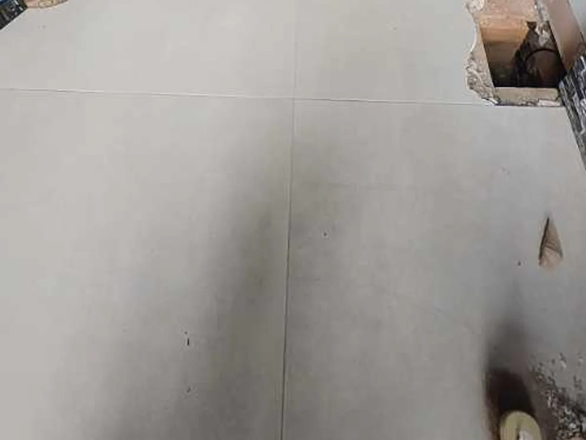 floor tiles excavated to expose pipework below, leak exposed at cold mains supply — leak located at