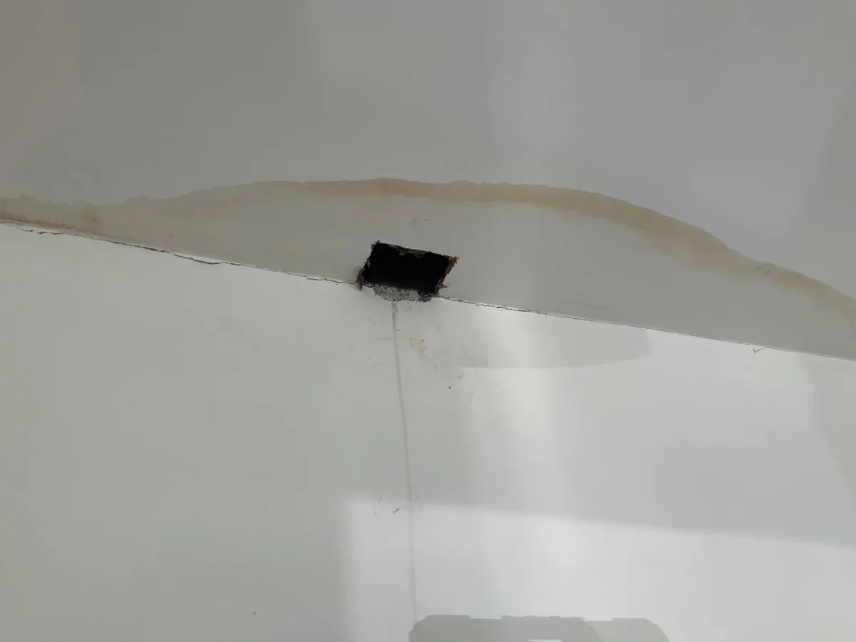 small access hole cut in living room ceiling during leak detection investigation