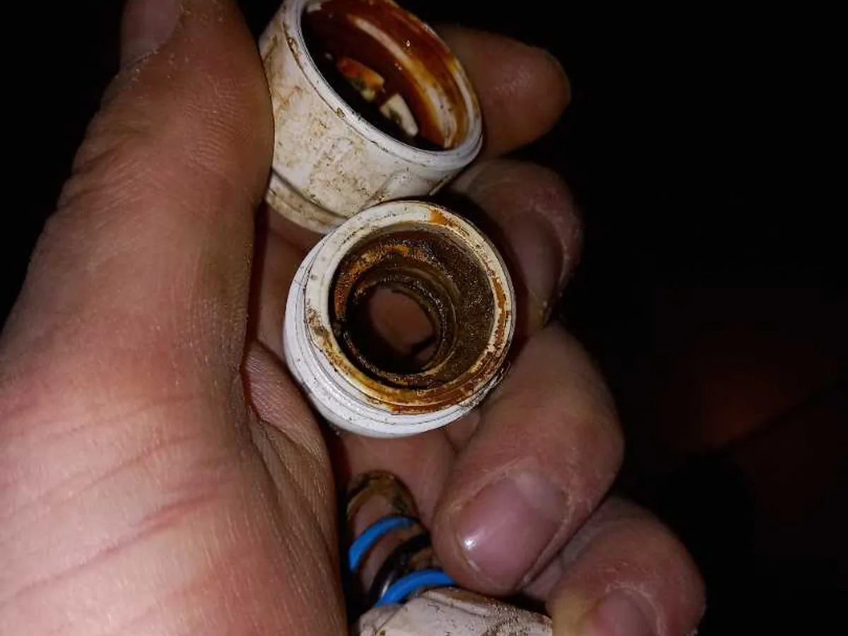 leak found at corroded push-fit pipe coupling held in hand showing internal rust damage