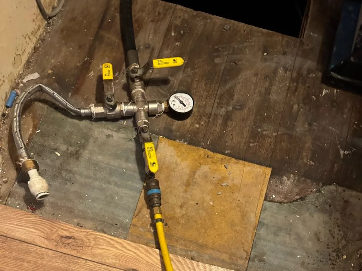 pressure test rig connected at under-stairs access hatch during leak detection