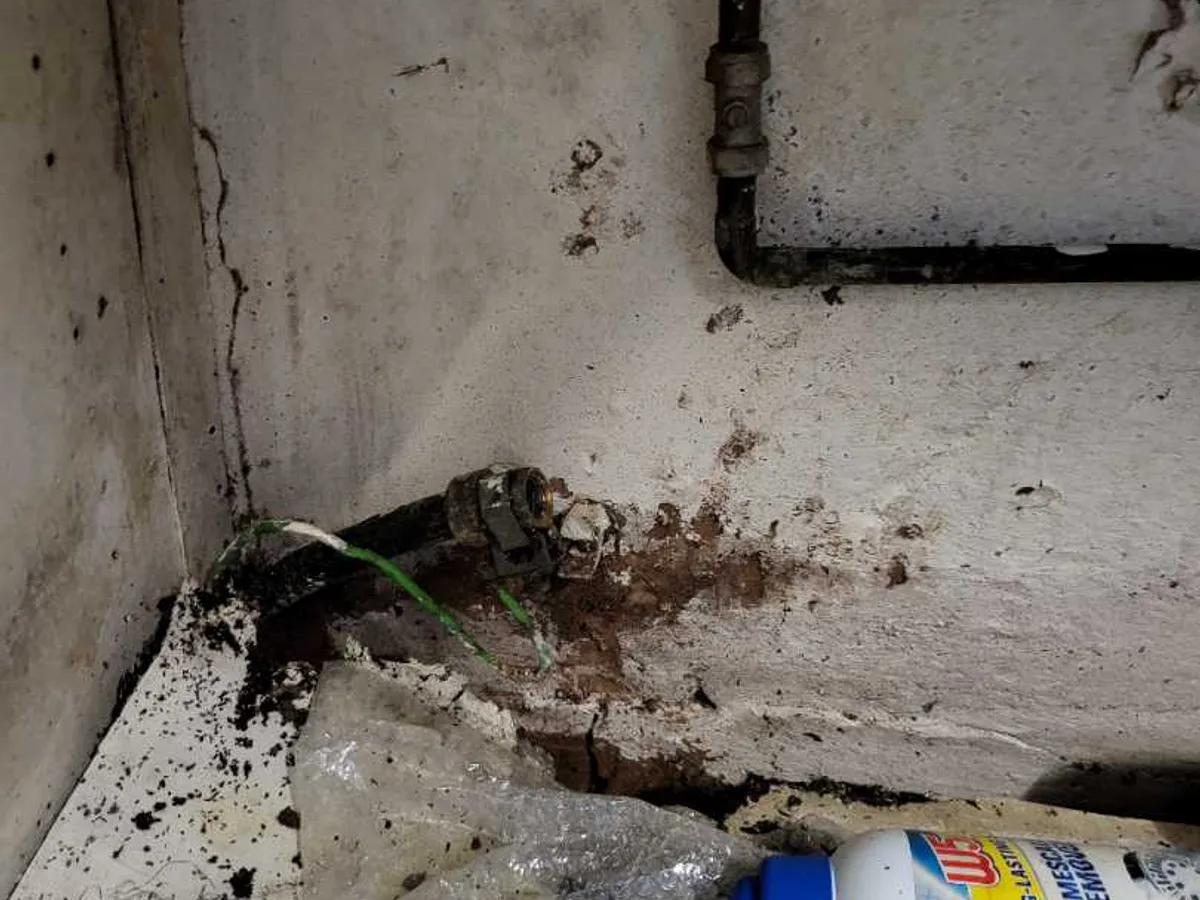 leak located at corroded underground mains supply pipe exposed beneath internal floor