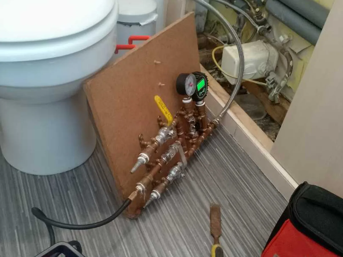 pressure testing rig connected to mains pipe under sink during leak detection survey
