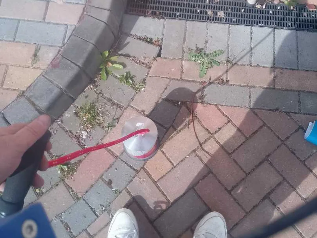 tracer gas detection probe applied to block-paved driveway during leak detection survey