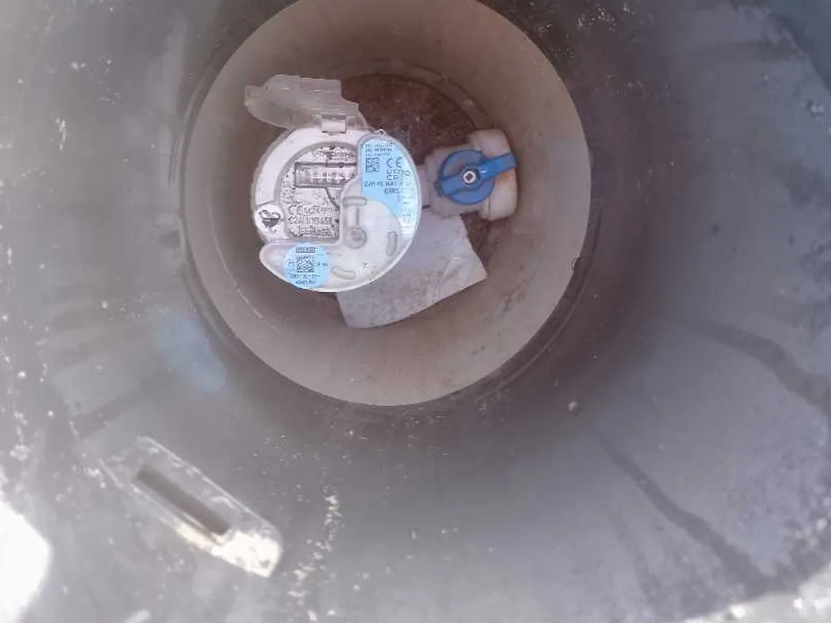 water meter inside underground chamber being checked during leak detection