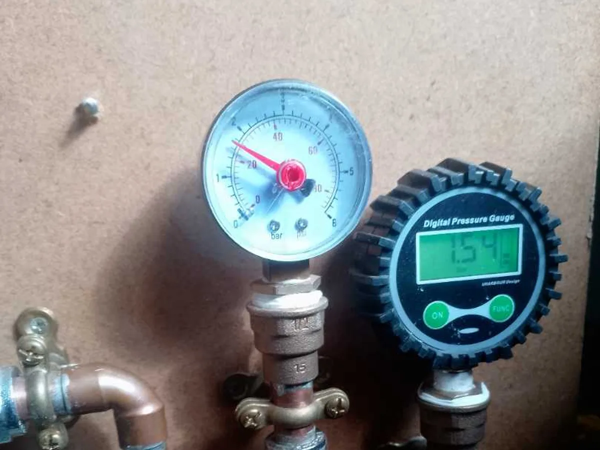 analogue and digital pressure gauges connected to cold mains pipework during leak detection