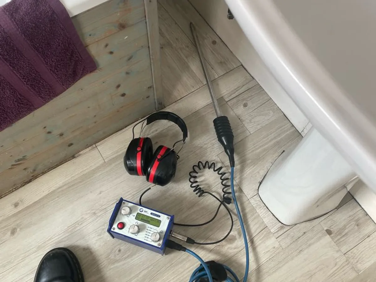 acoustic listening device and headphones on bathroom floor during leak detection