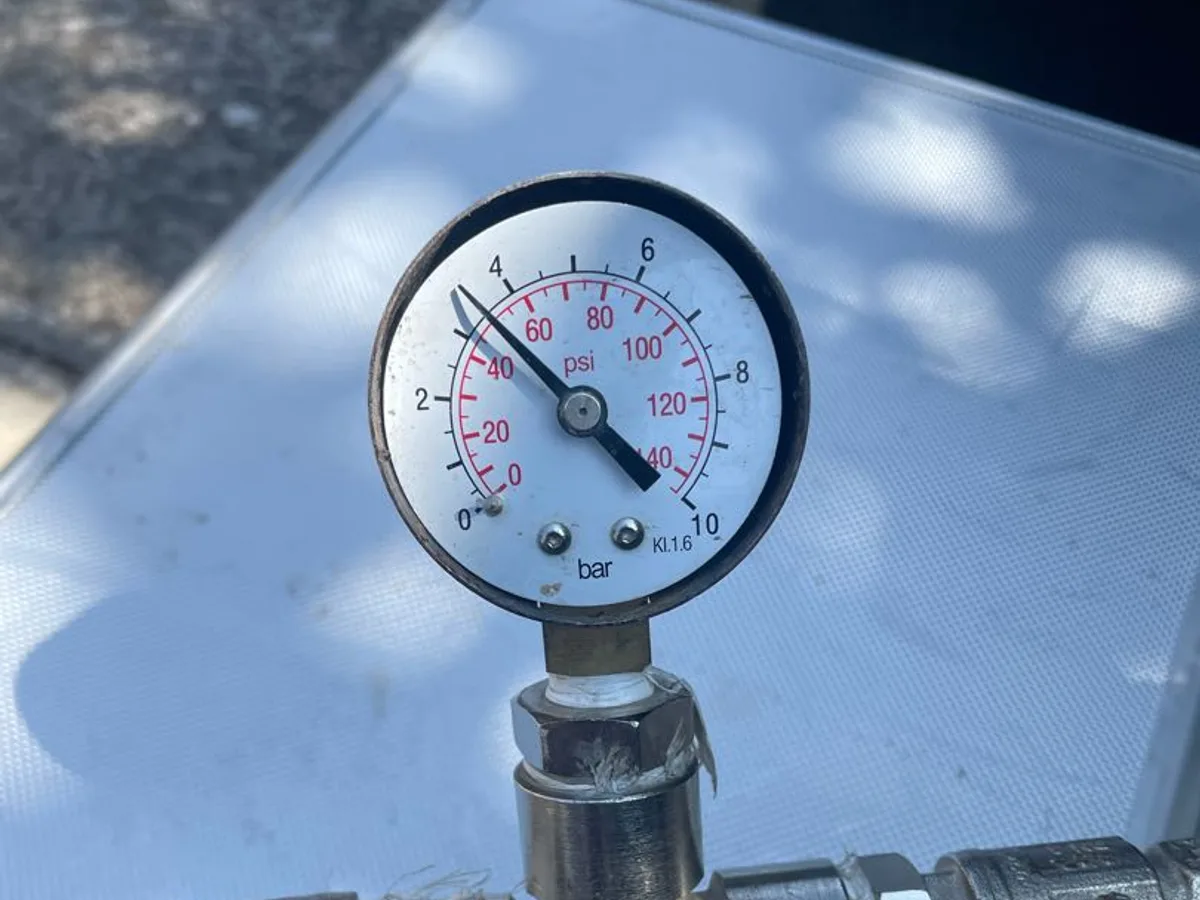 pressure gauge showing near-zero bar reading on test rig during leak detection