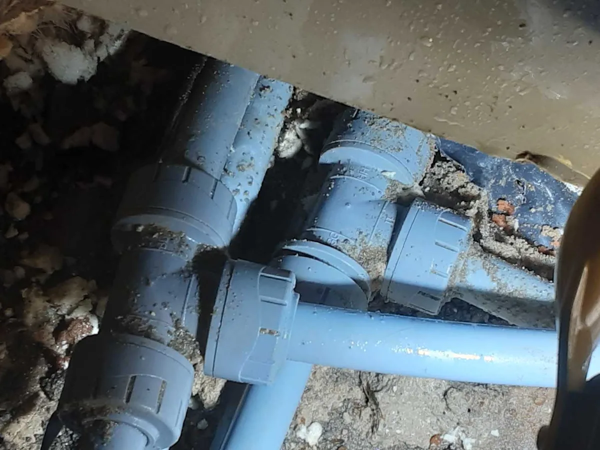 leak located at damaged plastic tee joint in pipework beneath kitchen concrete floor