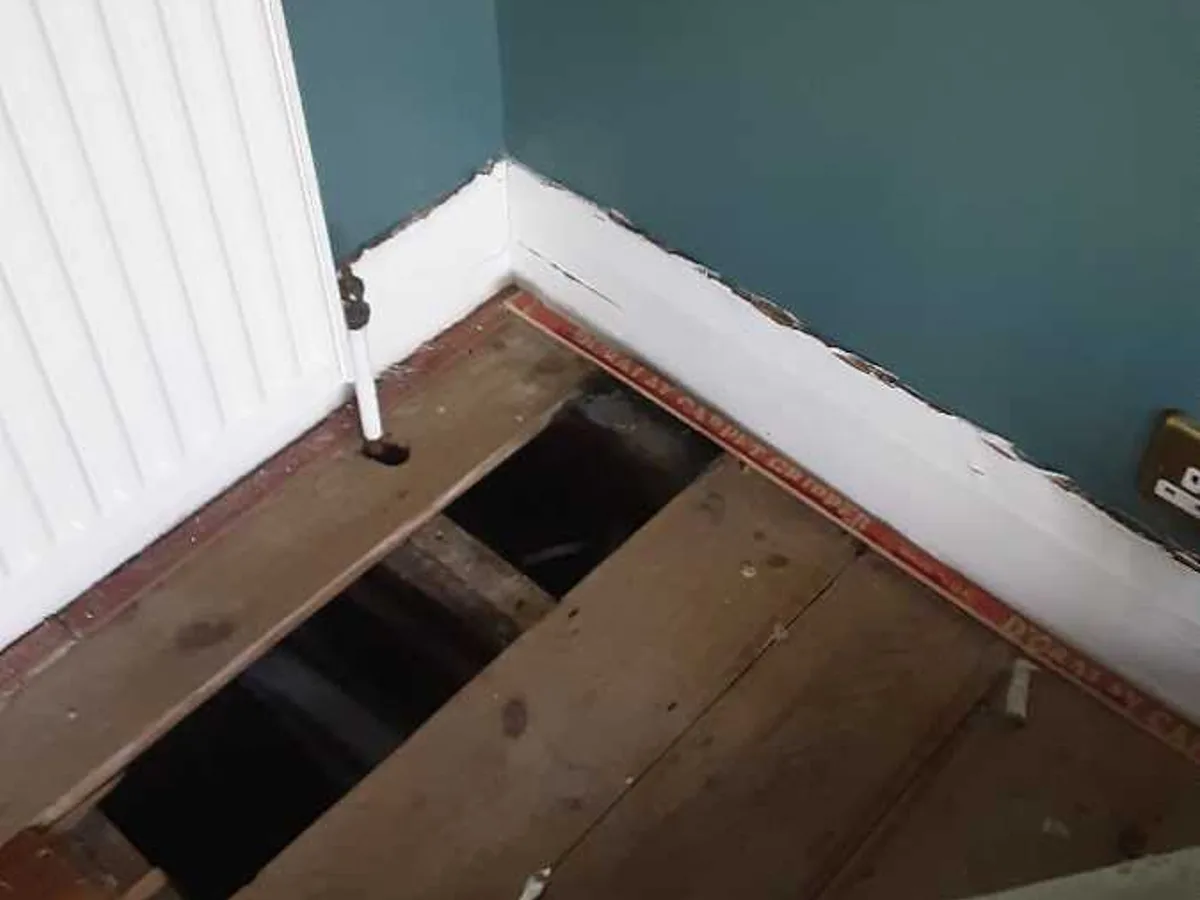 lounge floorboards lifted to reveal void beneath suspended floor before leak detection works