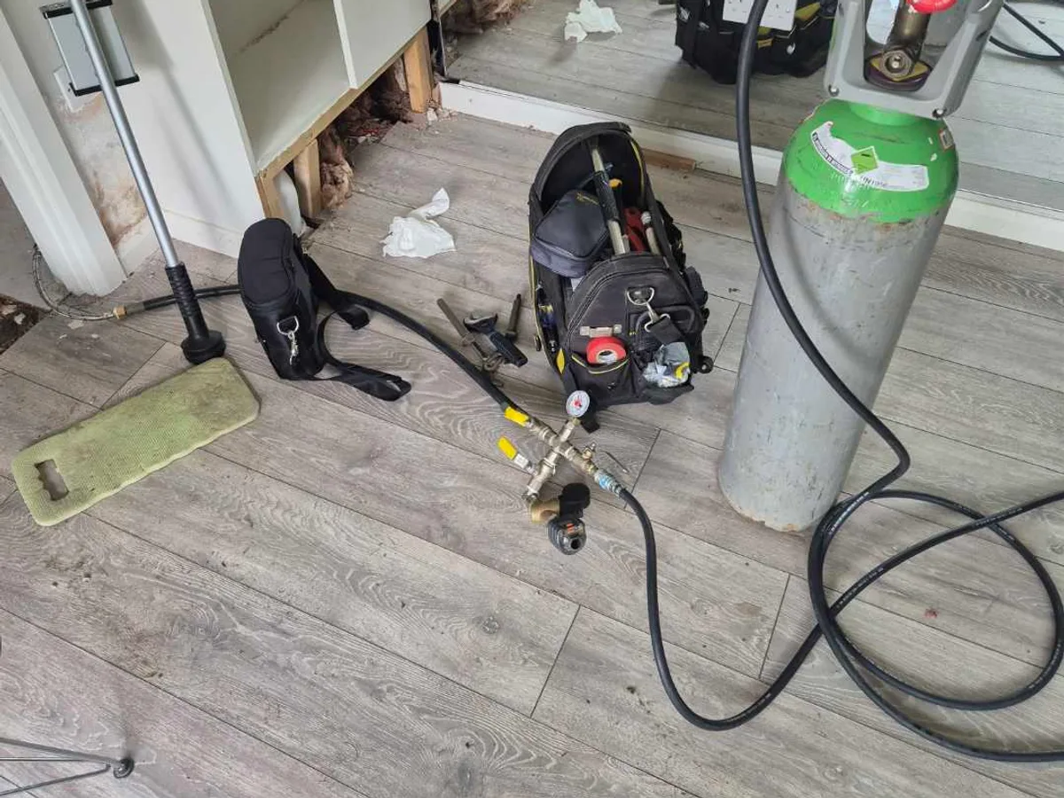 tracer gas cylinder with regulator and test manifold connected to mains supply during leak detection