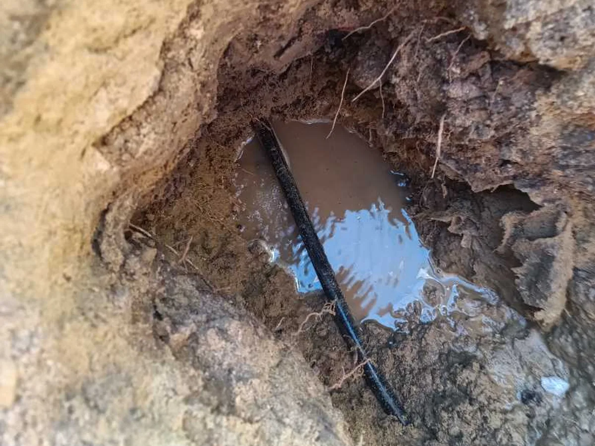 leak located at black 20mm poly pipe with standing water pooled in excavation beneath bricks