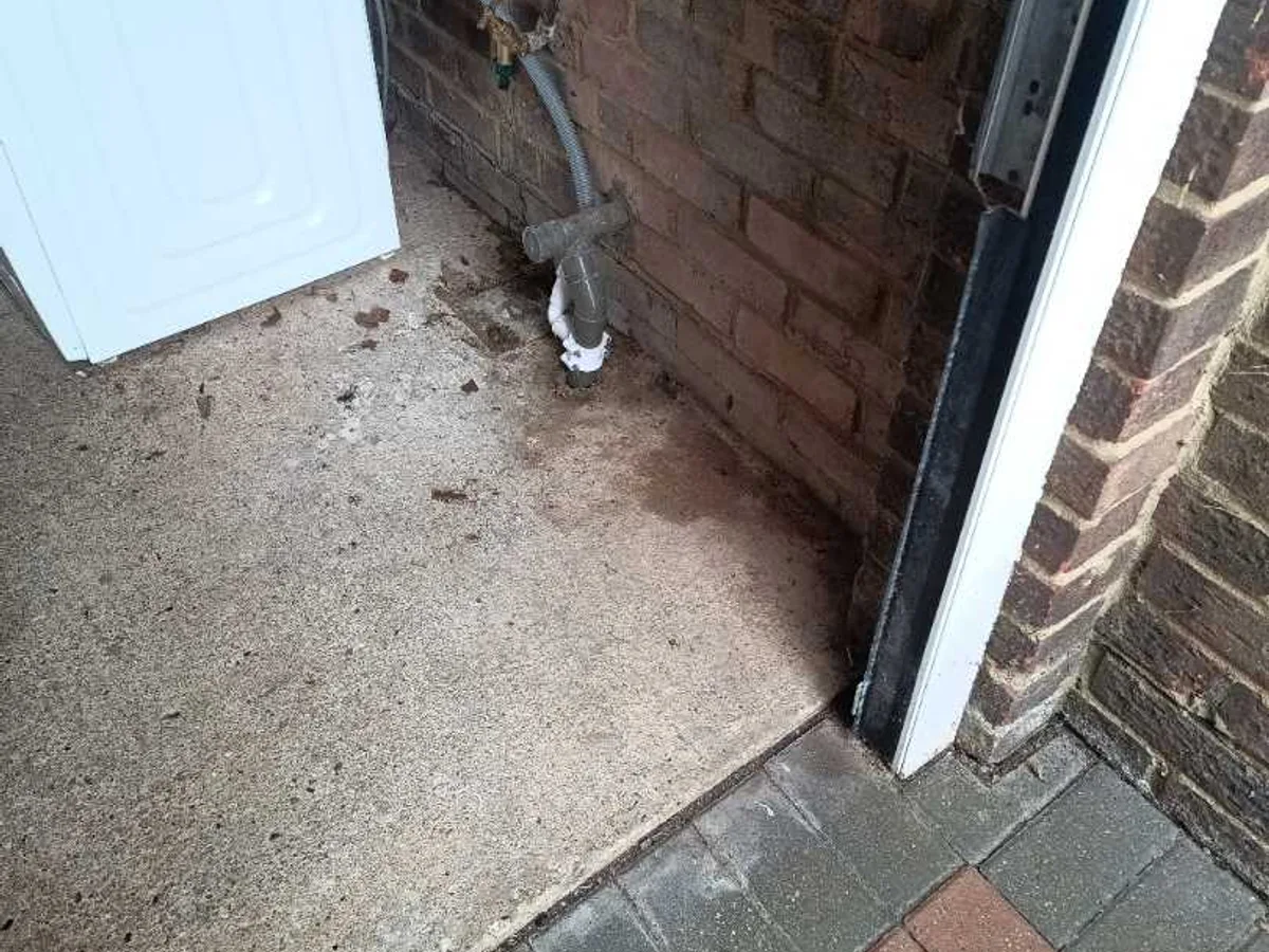 exposed pipework at garage entrance before leak detection works started