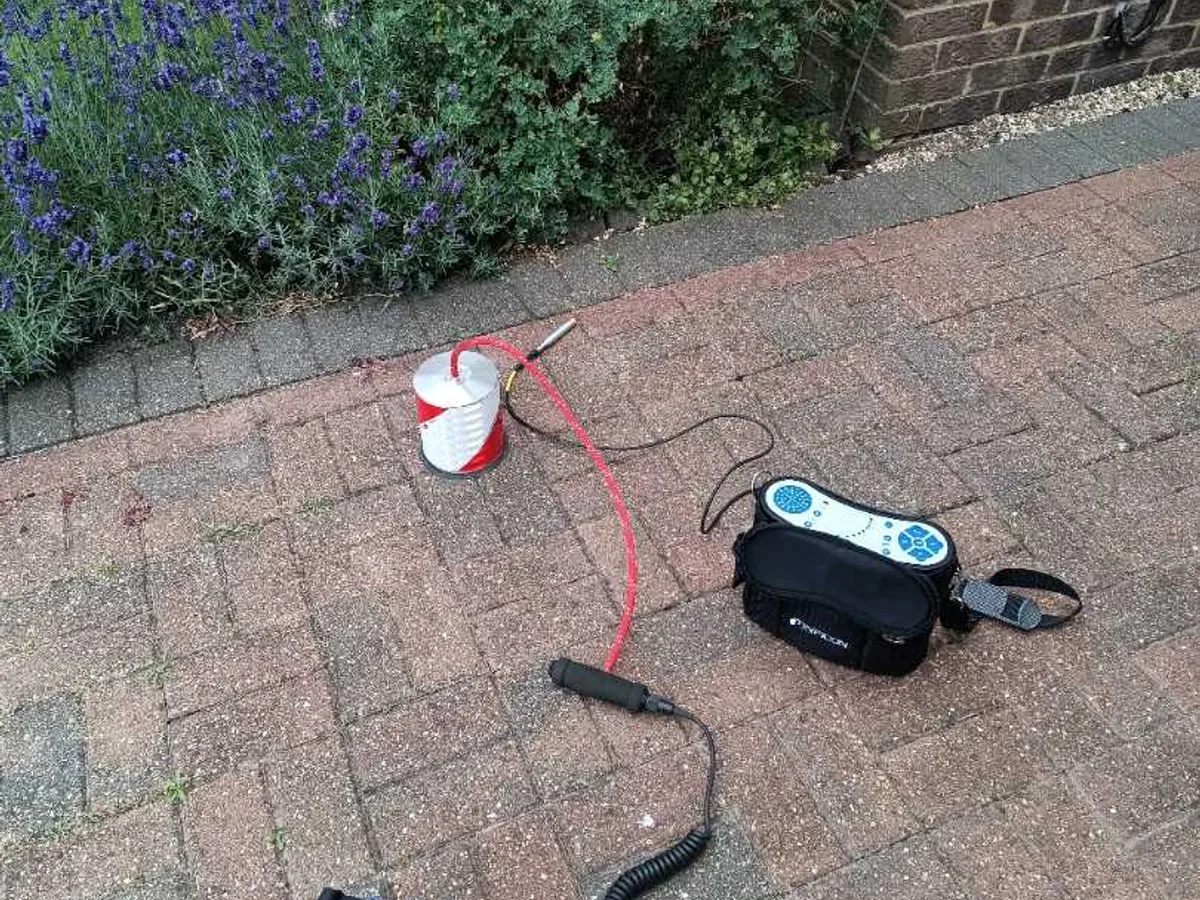 tracer gas canister and acoustic listening kit laid on block paving during leak detection